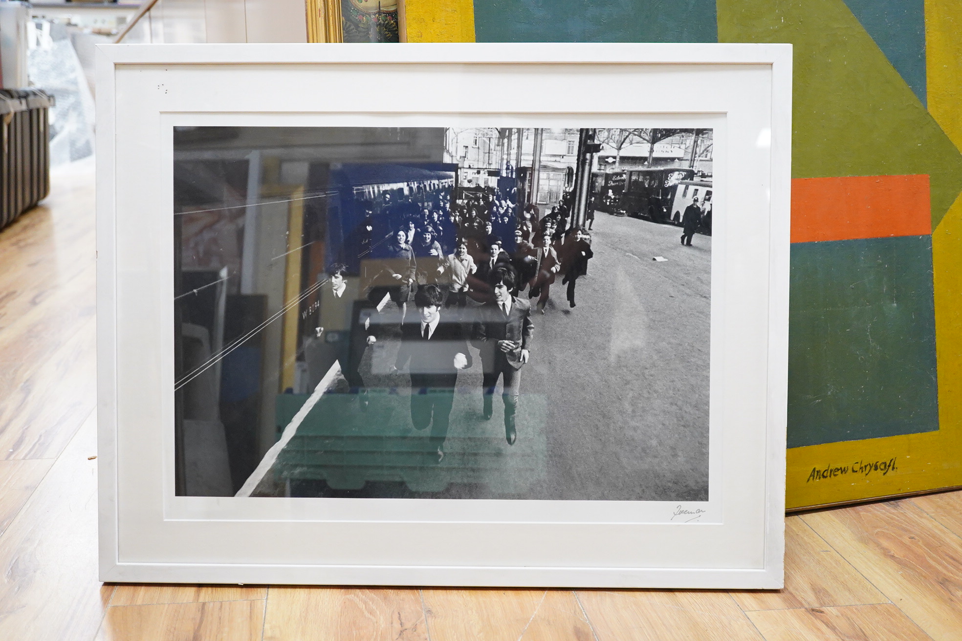 A framed and mounted black and white photograph of The Beatles by Robert Freeman, of a still from the film A Hard Days Night, signed in the margin at the bottom right, 42.5 x 58.5cm